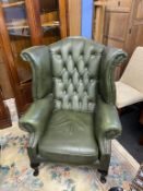 A green Chesterfield club chair and a high back armchair