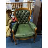 A green leather button back armchair