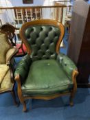 A green leather button back armchair