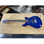 An electric blue guitar, serial number YAHC0556
