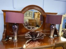 A pair of decorative purple glass table lamps and a large glass fruit bowl