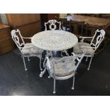 A metalwork patio table and four chairs, with cushions