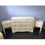 A cream chest of seven drawers and a matching pair of bedside tables, 123cm wide and 51cm wide