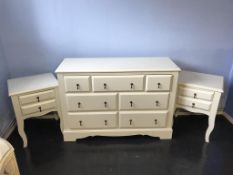 A cream chest of seven drawers and a matching pair of bedside tables, 123cm wide and 51cm wide