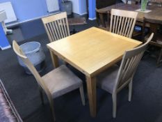 A modern oak extending dining table and four chairs