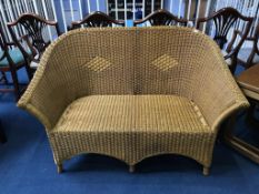 A wicker two seater conservatory settee