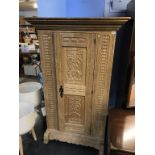 A heavily carved oak single door Continental wardrobe, 105cm wide x 165cm height x 59cm depth
