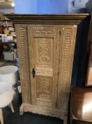 A heavily carved oak single door Continental wardrobe, 105cm wide x 165cm height x 59cm depth