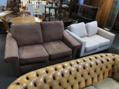 A brown two seater settee and cream settee