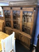 A good reproduction mahogany concave and breakfront bookcase, with three glazed doors and