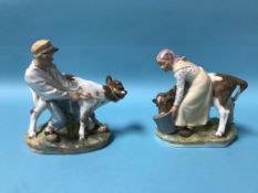 A pair of Royal Copenhagen figures of a boy pulling a cow and a girl feeding a cow