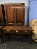 A reproduction mahogany campaign style double door wardrobe and three drawer side table