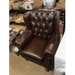 A large button back wing armchair and two valet stands