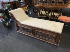 A carved oak chaise long