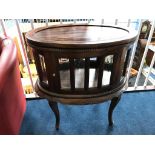 A reproduction mahogany oval display cabinet