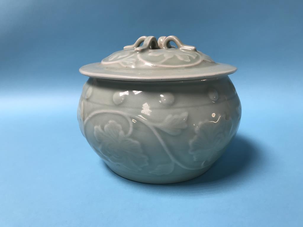 A Chinese celadon circular bowl and cover, marks in underglaze blue, 14cm high