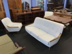A teak framed three seater settee and a pair of armchairs (possibly Swedish)