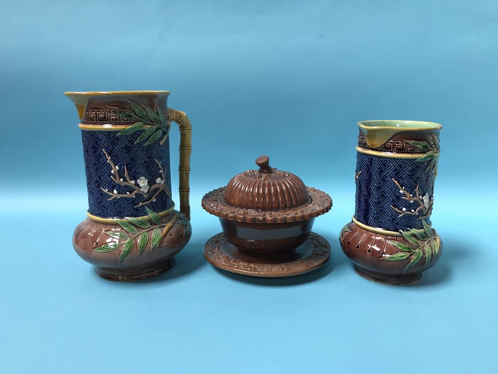 Two Minton Majolica water jugs, with bamboo handles, stamped 618, 24cm and 19cm height, and a salt