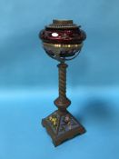 An oil lamp, with ruby coloured reservoir