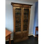 An early 20th century oak and leaded glass bookcase