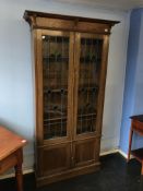 An early 20th century oak and leaded glass bookcase