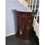 A 19th century bow front corner cabinet
