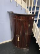 A 19th century bow front corner cabinet
