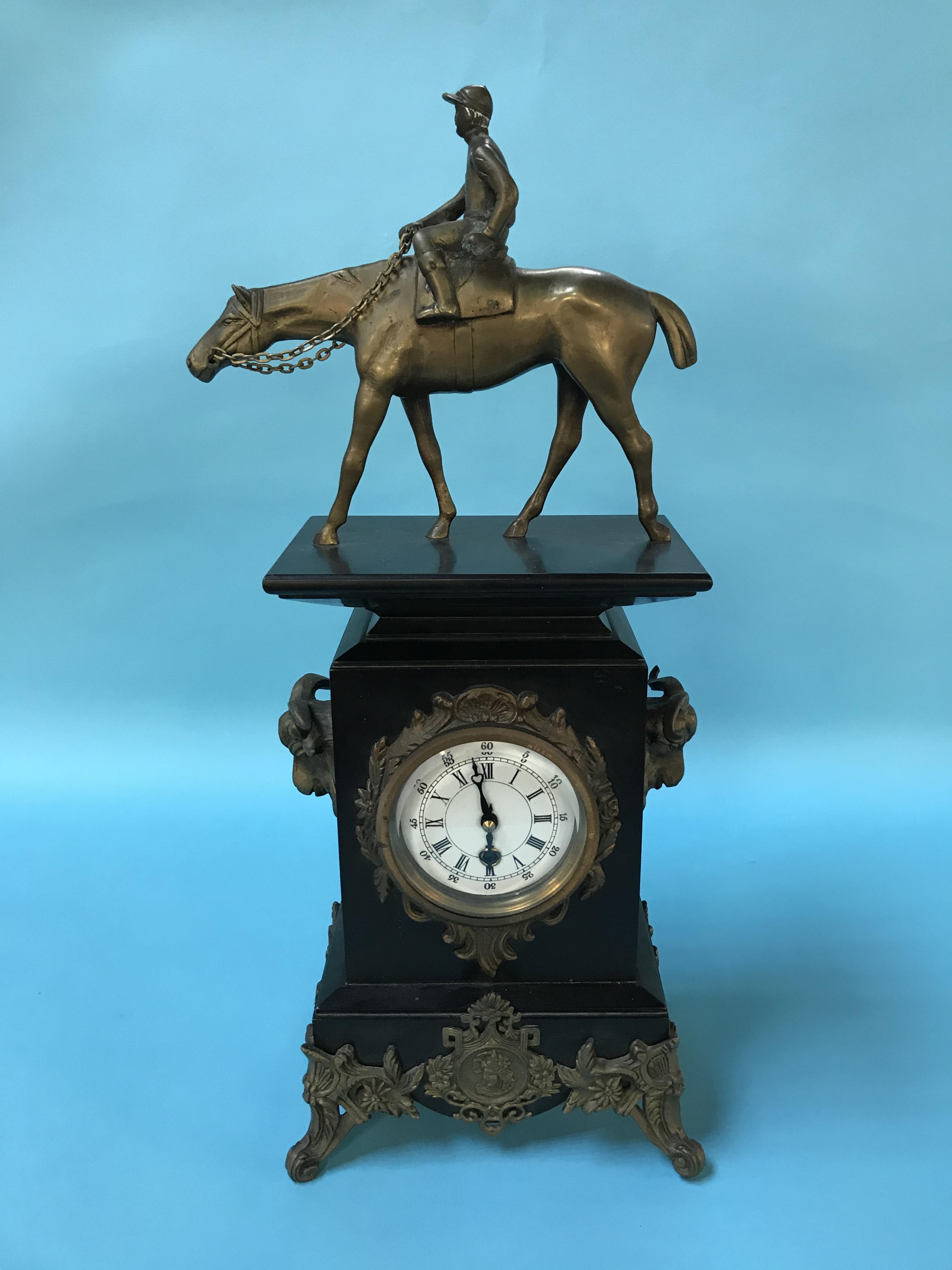 A slate mantel clock, surmounted with a brass horse and Jockey