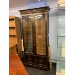 An oak two door cabinet, with leaded glass doors