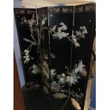 A decorative black lacquered Oriental four fold screen
