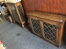 Two oak leaded glass display cabinets and an oval mirror