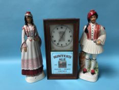 An Advertising wall clock 'Hunters Ales' and a pair of Italian figures