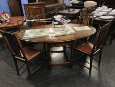 An oak carved gateleg table and four chairs