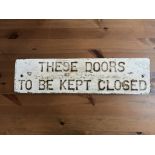 A cast sign 'These Doors to be kept Closed'