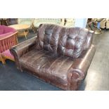 A brown leather two seater settee