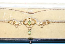 An Edwardian yellow metal necklace and pendant, mounted with seed pearls and peridot, 5.8g