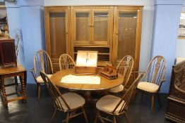 An Ercol dining room suite comprising extending table, six chairs and a three section display unit
