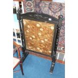 An ebonised fire screen