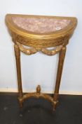 A half moon gilt wood and marble inset hall table