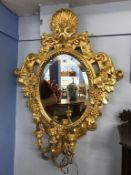 A pair of gilt oval mirrors, with three sconces, 98cm x 78cm