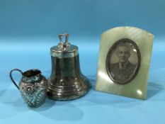 A silver bell shaped inkwell, a small silver jug and an onyx and silver mounted frame