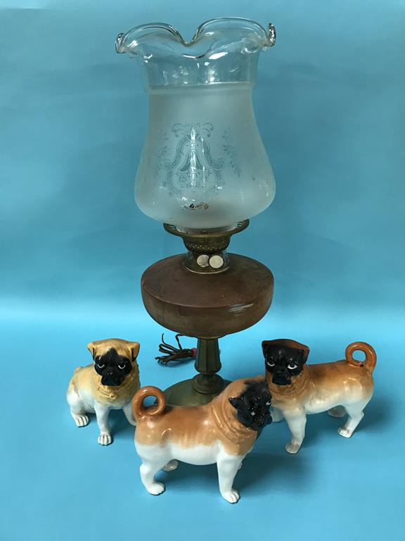 An oil lamp and three porcelain pug dogs
