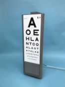 A wall mounted triangular and rotating eye test panel, H 66cm
