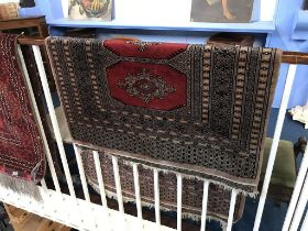 A Pakistani rug, with double row of medallions on madder red ground, with main hooked border and