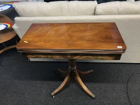 A reproduction mahogany fold over card table