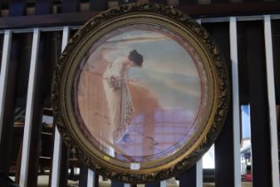 A large circular and gilt framed print of a lady picking shells off a beach and three prints after