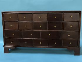 A mahogany bank of nineteen drawers, with turned brass handles, on bracket feet, 83 x 47 x 22cm