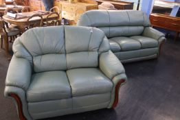 A green leather two seater settee and three seater settee