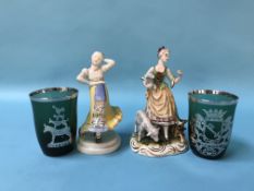Two continental porcelain figures and two continental green glass and silver mounted beakers
