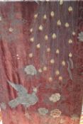 A long Victorian needlework wall hanging, the burgundy velvet ground decorated with peacocks and